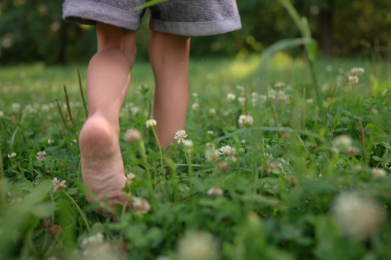 Ett barn leker barfota i naturen.